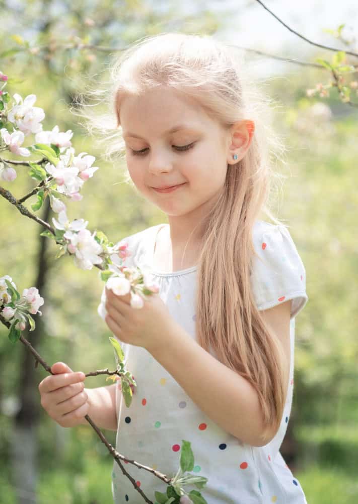 a girl standing by a tree